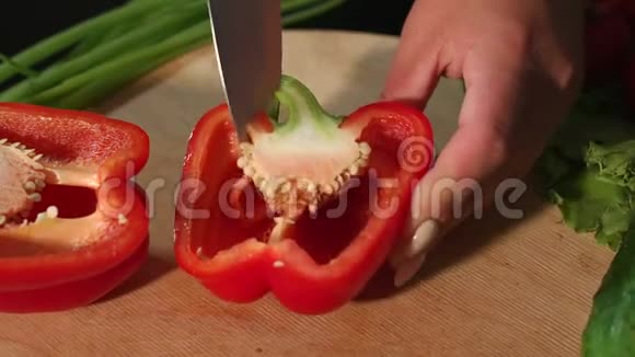 一个女人在木板上切成熟多汁的红椒的特写镜头视频的预览图