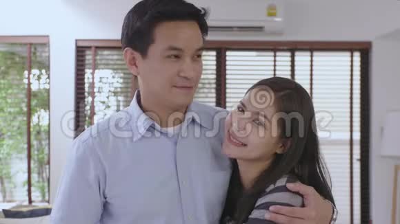 家庭幸福的年轻亚洲夫妇的肖像男人表达他的情感亲吻他的妻子视频的预览图