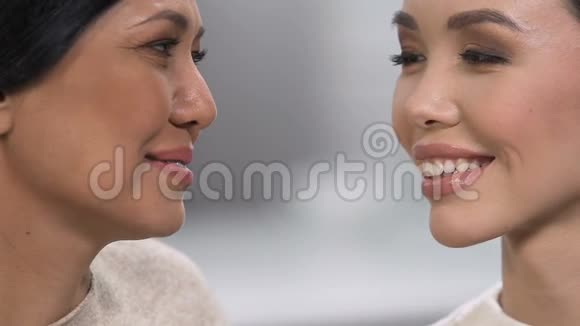 美丽的亚洲女性微笑着看相机抗衰老化妆品面部特写视频的预览图