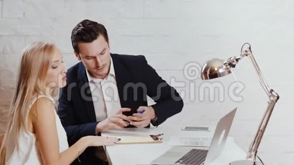 男人和女人正在办公室里看电脑视频的预览图