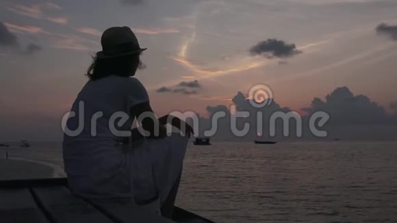 女孩坐在岸边看日落马尔代夫录像特写视频的预览图