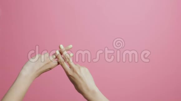 一个女孩的交叉手指在粉红色的工作室背景下手显示标签形状概念社交网络索引屏幕视频的预览图