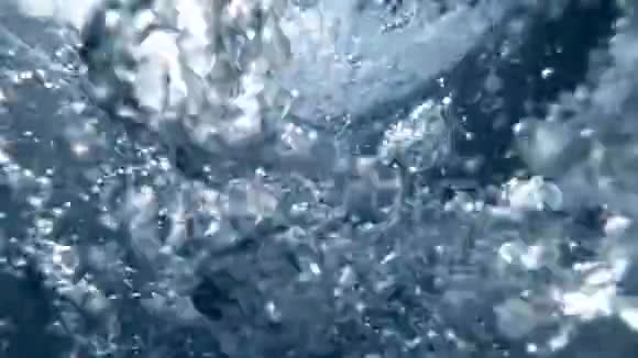 潜水时潜水者释放空气的慢动作镜头气泡从海底飘到水面视频的预览图