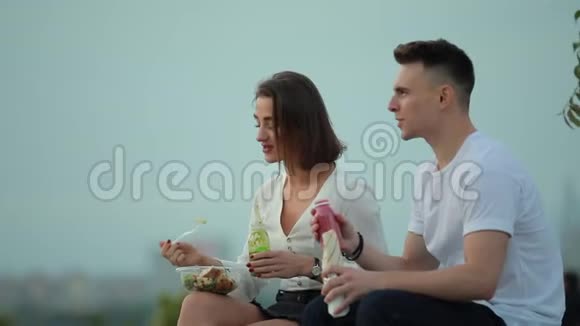 年轻夫妇在户外吃沙拉和喝冰沙视频的预览图