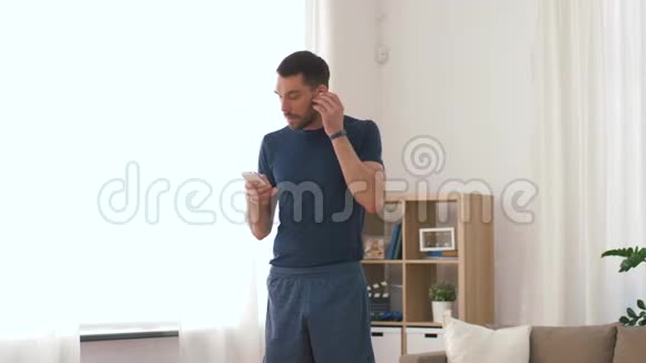 带无线耳机的男士在家锻炼视频的预览图