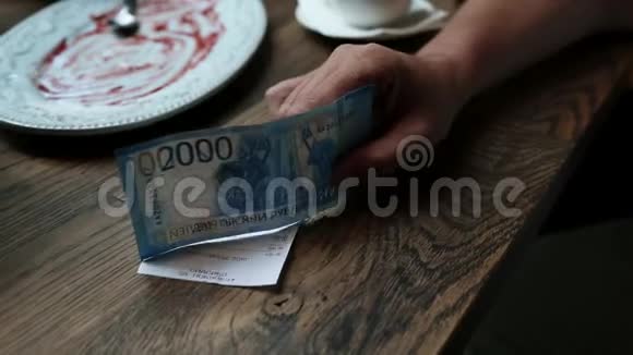 在咖啡馆付现金的人纸币在人手餐厅支票在木桌上视频的预览图
