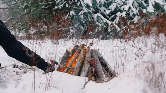篝火晚会一个人在冬天的森林里生火视频的预览图