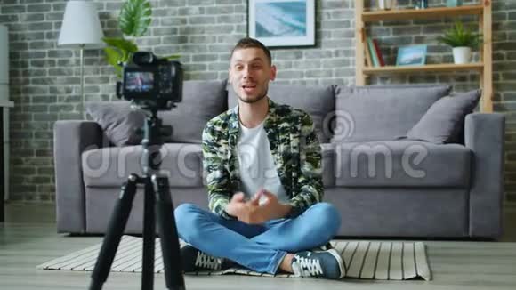 男子vlogger记录视频博客谈话手势使用相机三脚架视频的预览图