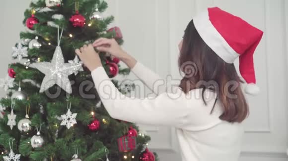 一群快乐的年轻亚洲女人在圣诞节的时候在家里的客厅里互相赠送圣诞礼物视频的预览图