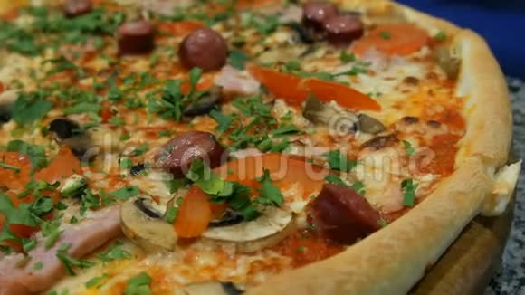美味的新鲜比萨饼与巴伐利亚香肠蘑菇培根西红柿绿色近景视频的预览图