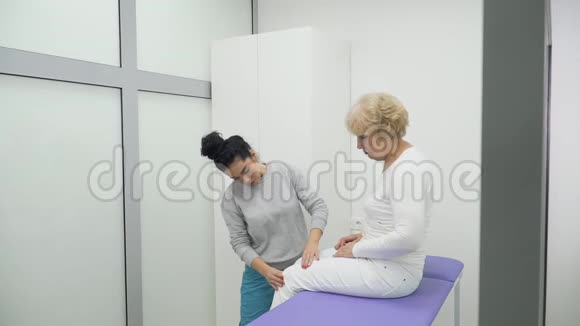 医生在诊所检查老年妇女腿视频的预览图