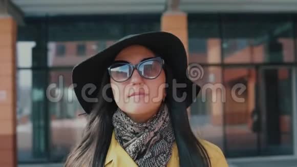 戴着帽子戴着眼镜走在街上的时髦女孩视频的预览图