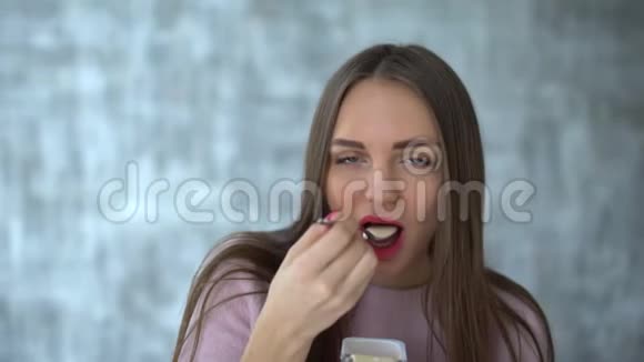 女人吃酸奶漂亮的年轻女人吃酸奶节食的年轻女人吃白色酸奶可爱迷人视频的预览图