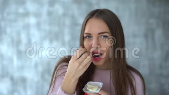 女人吃酸奶漂亮的年轻女人吃酸奶节食的年轻女人吃白色酸奶可爱迷人视频的预览图