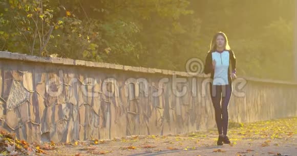 女人在阳光城市公园跑步晨曦视频的预览图