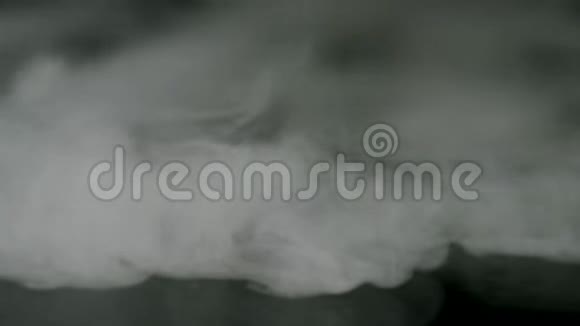 烟雾碎片在黑色背景上流动库存录像美丽的白云慢慢地被隔绝视频的预览图