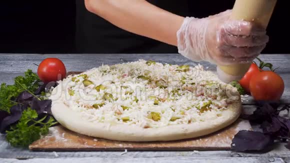 用白色橡胶手套煮手在披萨基地加入酱汁烹饪理念框架准备手工披萨视频的预览图
