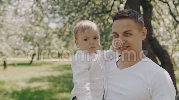 父亲和儿子在公园看相机年轻的父亲和小儿子在户外视频的预览图