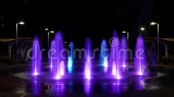 城市中一个夜晚发光的行人喷泉的时间推移视频水射流在地面的上方猛扑美丽美丽视频的预览图