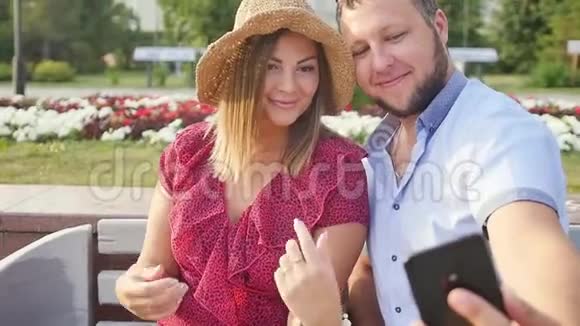 年轻夫妇在城市公园放松时拍自拍快乐的恋人想要捕捉一个愉快的时刻视频的预览图