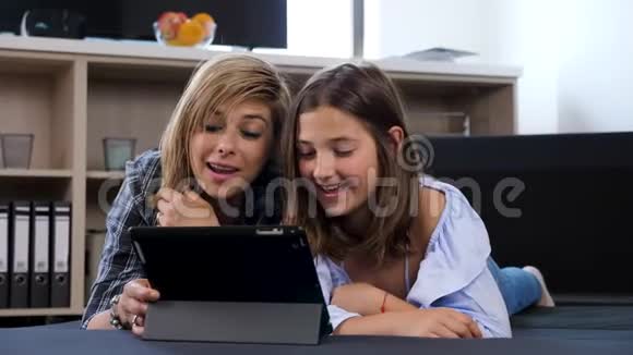 女人和她的女儿通过平板电脑通过视频通话与某人交谈视频的预览图
