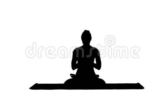 年轻女子练习瑜伽坐在莲花的位置上闭着眼睛冥想着冰铜视频的预览图