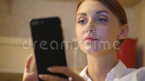 漂亮的女孩在智能手机上发短信脸部特写视频的预览图