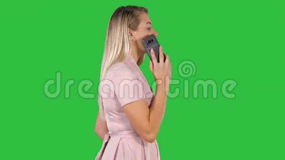 年轻的女士在绿色屏幕上打电话Chroma键视频的预览图