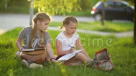 孩子们在夏天的花园里读一本书学前朋友游戏和学习女孩做家庭作业视频的预览图