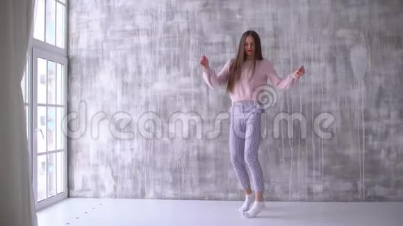 可怕的白种人迷人的快乐的快乐的舞蹈女孩在灰色工作室背景下跳舞4k女子视频的预览图