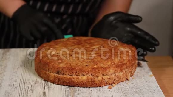 从烤箱里取出现成的海绵蛋糕切成蛋糕层用来做坚果香蕉蛋糕视频的预览图