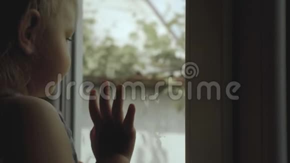 母亲站在一扇窗前一个小孩子站在一个剪影里视频的预览图
