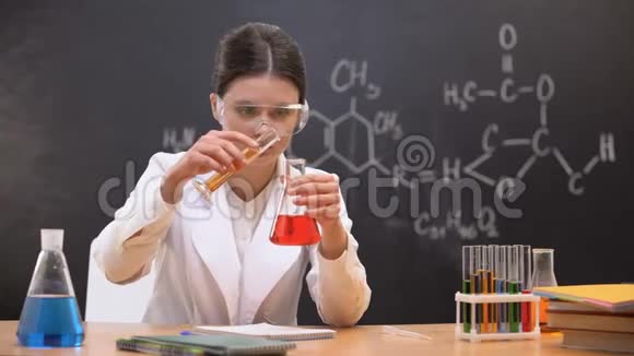 化学学生混合液体在实验室和写作结果实验视频的预览图