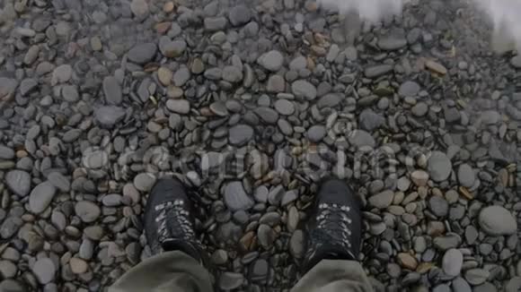 靴子在石滩的顶部附近射击在腿上挥动慢动作视频的预览图