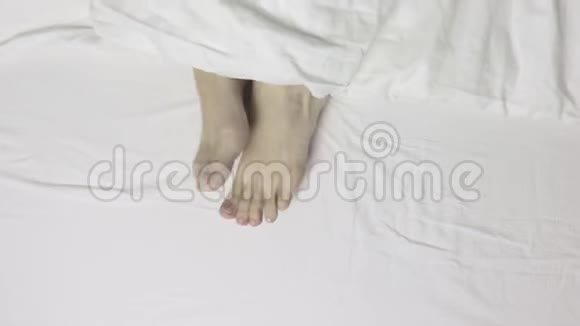 女士双脚躺在床上俯视早上醒来放松视频的预览图