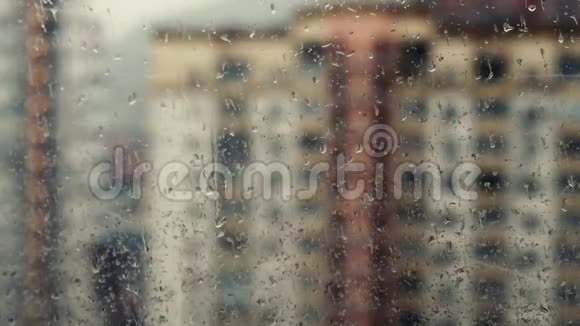 窗玻璃上的雨水落在建筑物上视频的预览图