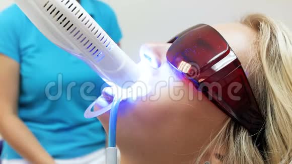 特写4k视频年轻金发女子戴防紫外线眼镜坐在牙医椅上视频的预览图