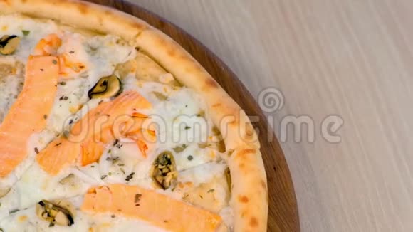 四分之一的切片披萨与海鲜和奶酪在木板上近距离观看视频的预览图