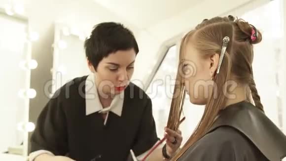 女性发型师用剃刀在美容工作室剪长发在美发沙龙中关闭女性发型视频的预览图