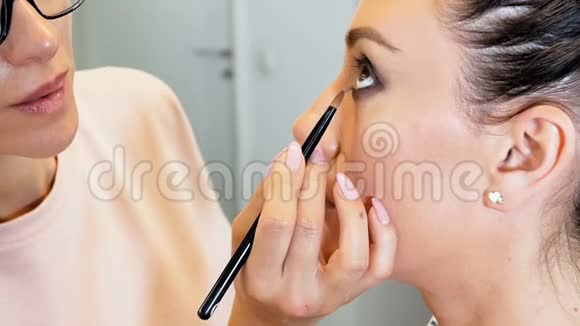 特写慢镜头的专业视觉绘画模特的眼睛化妆师给女孩化妆视频的预览图