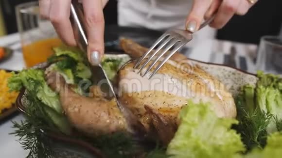 特写女人用刀切烤箱烤鸡家庭晚餐视频的预览图