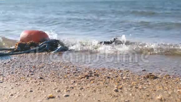 海浪中的浮标在海岸的沙滩上视频的预览图