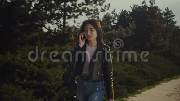 亚洲女人在公园里用手机说话视频的预览图