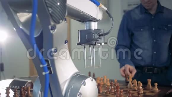 一个成年男子和一个机器人正在下棋互相捕捉对方棋子视频的预览图