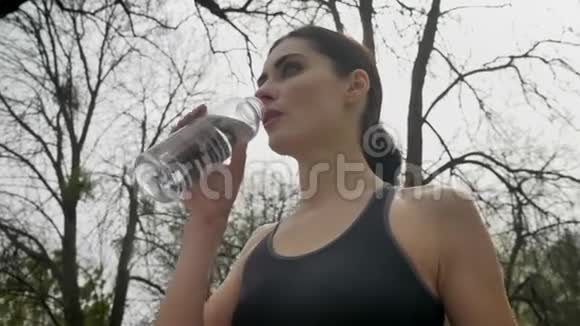 年轻健康的女运动员夏天在公园里喝水健康的生活方式运动观念底景视频的预览图