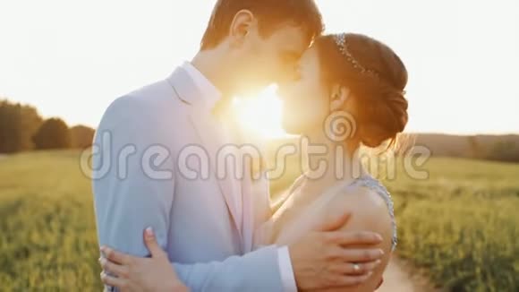 新娘和新郎拥抱在一起在乡间的路上微笑夕阳视频的预览图