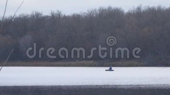 在秋湖上坐船的渔夫钓到了旋转的梭子鱼视频的预览图