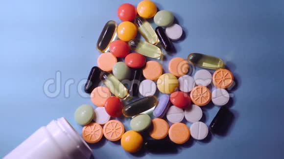 蓝色背景下的药丸药片胶囊和瓶子视频的预览图