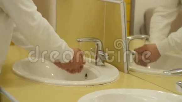 在公共卫生间用白色衬衣洗手的特写男士视频的预览图