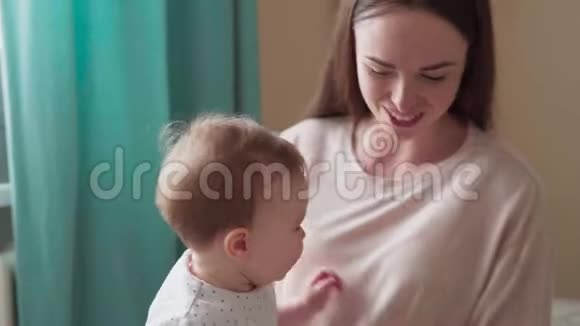 快乐的妈妈亲吻拥抱她的小宝宝视频的预览图
